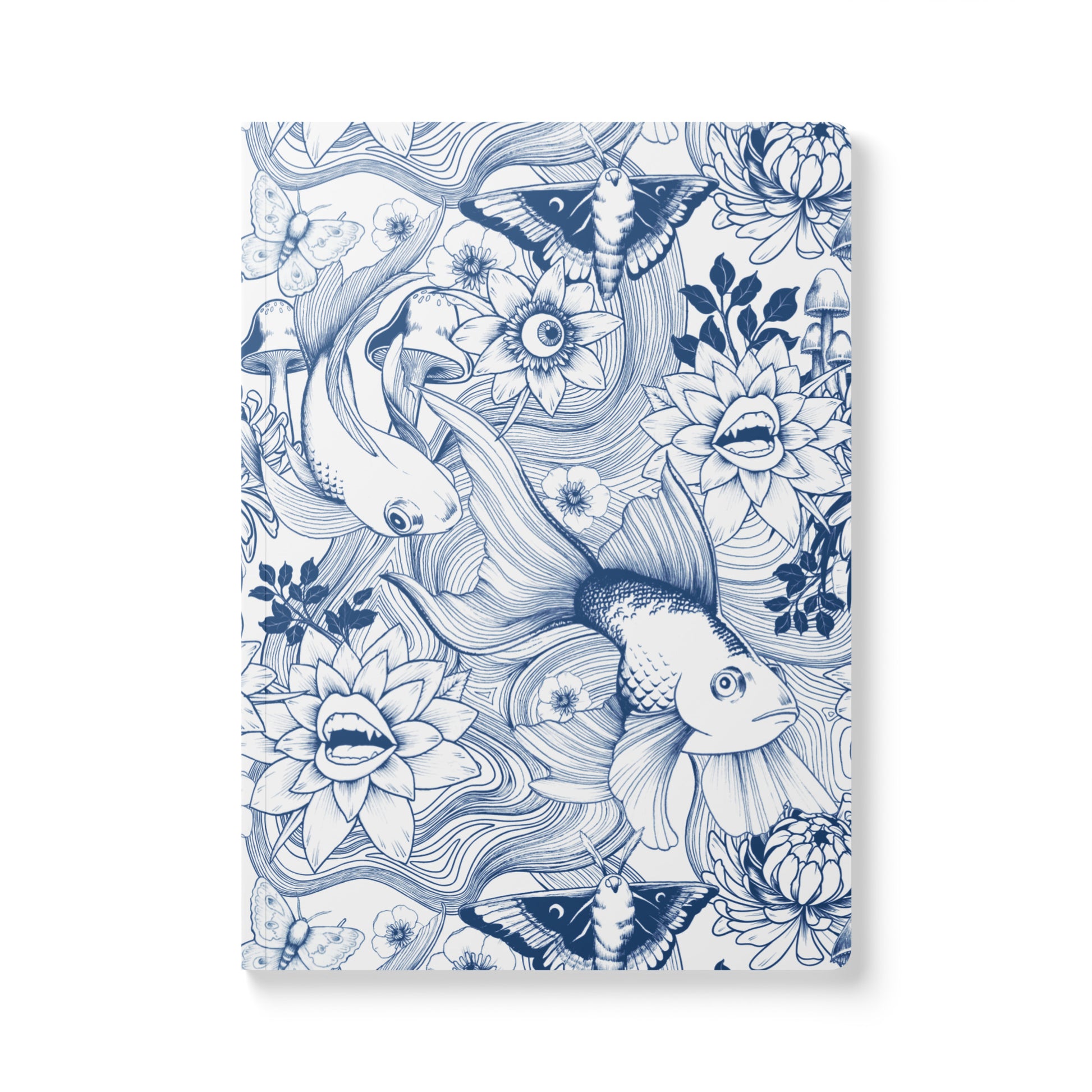 A front-facing view of a rectangular softcover journal with rounded corners, featuring a detailed dark blue ink illustration pattern on a white background. The surreal pattern includes large goldfish, moths, mushrooms, and whimsical blooming flowers with fanged teeth and human eyes.