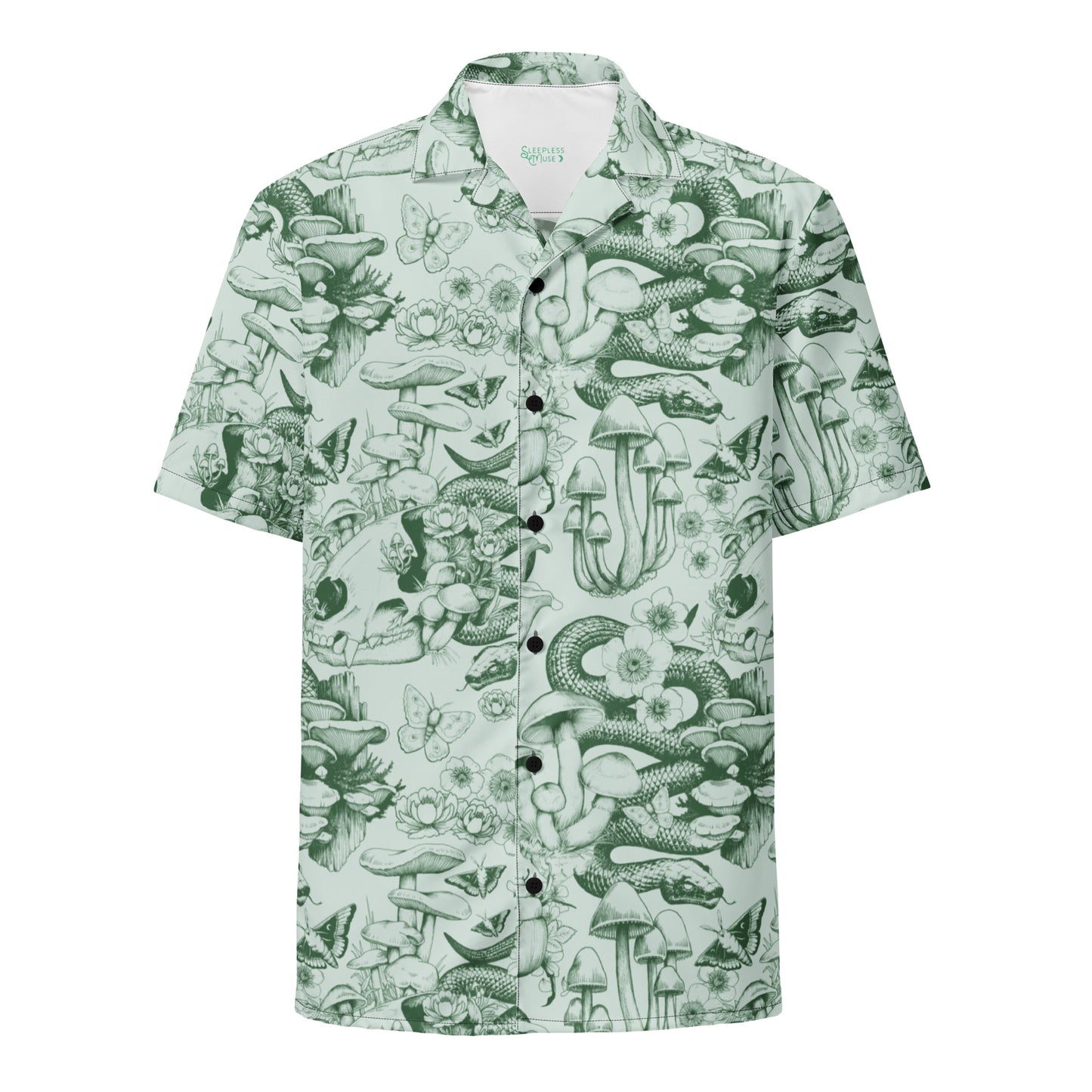 A flat-lay product photo of a short-sleeve, button-down Hawaiian-style shirt with an oversized fit. The shirt features an all-over, monochrome forest floor pattern in dark green ink over a light sage green background. The detailed illustration includes coiling snakes, clusters of tall mushrooms, animal skulls, butterflies, and small wildflowers. The shirt has black buttons down the center and a white inner collar showing a small green logo.A flat-lay product photo of a short-sleeve, button-down Hawaiian-sty